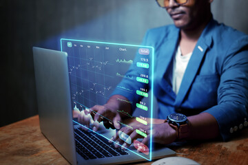 online trading concept Business man analyzes daily online stock market prices with graphs displayed on technology laptop screen.	