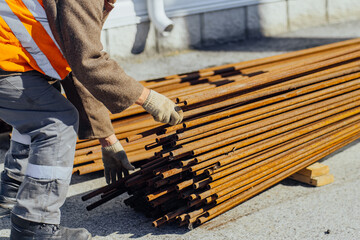 Slinger stacks thin metal pipes in stack on construction site. Close-up. Real workflow. Unloading...