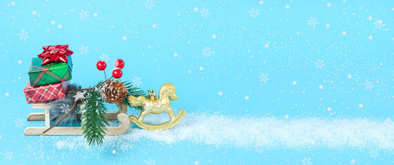 Fototapeta na wymiar Blue background baner with sled and horse with Christmas and New Year gifts with snow with copy space