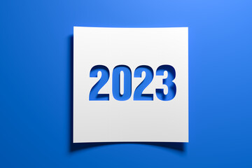 A piece of curved memo paper with the cut out number 2023 on blue background. Concept for events in...