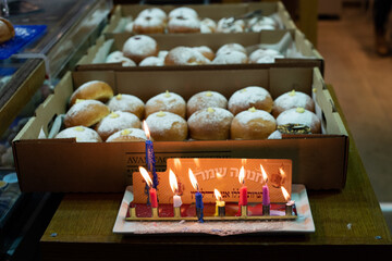 A Hanukkah menorah burns in a Jerusalem bakery selling sugar-coated donuts  during the celebration...