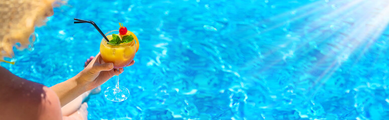 Woman with cocktail near the pool. Selective focus.