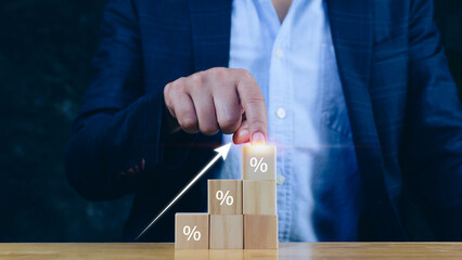 Businessman  hand choose the wooden block with percentage sign and up arrow, monetary growth,...