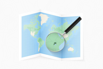 Enlarge Uganda with a magnifying glass on a folded map of the world.