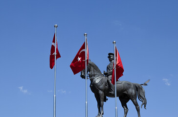 Statue of Mustafa Kemal Atatürk, the founder of the Turkish Republic, on a horse, in Ankara.Foreground flags of the republic of Turkey.