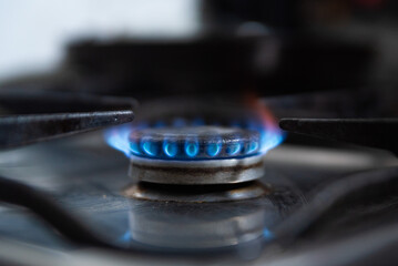 In this close up a blue gas flame from a gas burner is seen in a kitchen. Due to Russia's invasion...