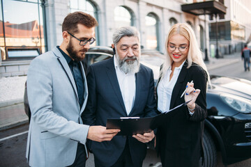 Business people discussing document on a meeting on the street