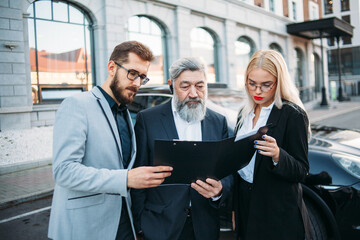 Business people discussing document on a meeting on the street