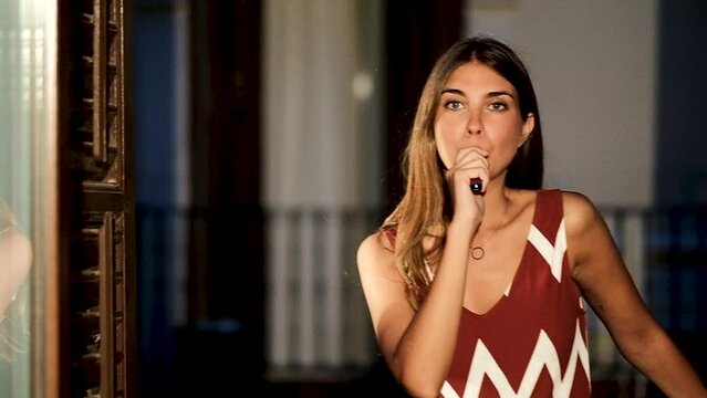Relaxed young woman smoking at flat