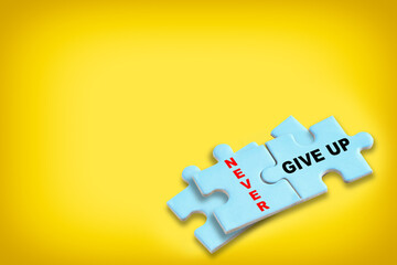Never give up written on blue puzzle isolated on yellow background. Business leadership development...