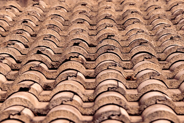 Weathered Spanish clay roof tile rooftop pattern background.