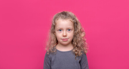 Little nice-looking lovely sweet curious cheerful girl on the pink color background.