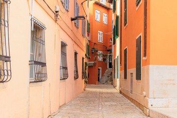 Fototapeta premium Old town alley in the Croatian town of Rovinj with old residential building fronts and freely laid power cables