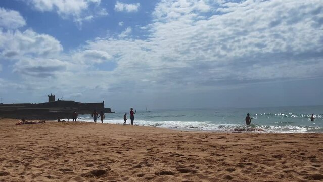People enjoying their time on the beach in Carcavelos, Portugal