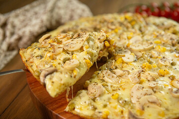 Fatia de pizza sendo retirada com queijo mussarela, champignons, milho verde, azeitonas. Close-up e foto seletivo