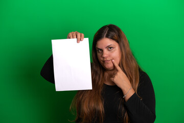 Naklejka premium Young woman holding a empty white paper, Green Background