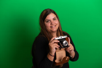 Young woman holding a vintage camera, on green screen 