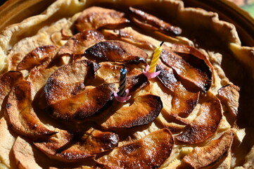 Close up of an apple tart with candles.