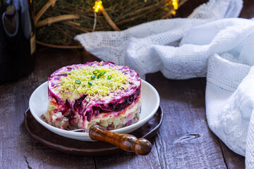 Dressed herring, raditional Soviet festive salad of herring and vegetables in a New Year's decoration.