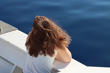 Girl from the boat in navigation looks at the sea-