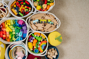 Colorful Toy Storage Baskets in the children's room. Cloth stylish Baskets with wooden toys. Organizing and Storage Ideas in nursery. Clean up toys and reduce the clutter. Top view