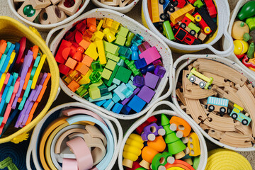 Colorful Toy Storage Baskets in the children's room. Cloth stylish Baskets with wooden toys. Organizing and Storage Ideas in nursery. Clean up toys and reduce the clutter. Top view