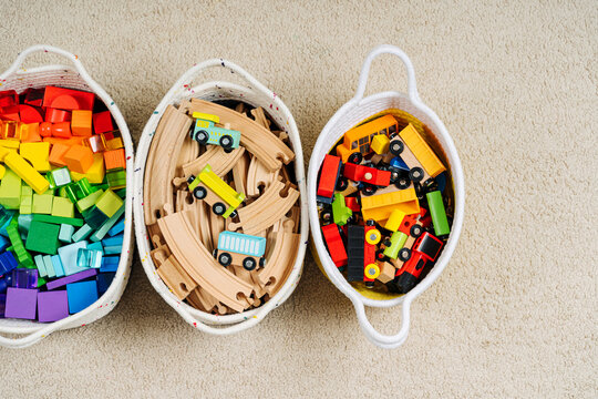 Colorful Toy Storage Baskets in the children's room. Cloth stylish Baskets with wooden toys. Organizing and Storage Ideas in nursery. Clean up toys and reduce the clutter. Top view