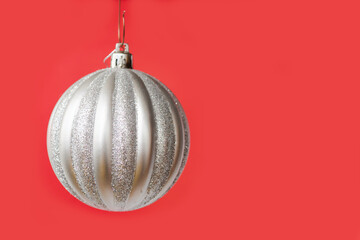 Silver ball on a red background. Festive background with place for text