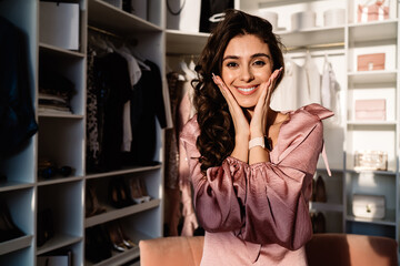 Charming woman touching face in closet at home