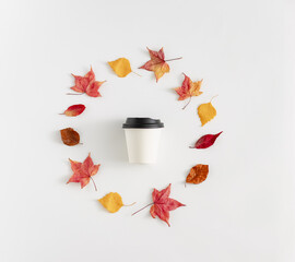 Autumn coffee menu. White plastic cup with yellow leaves . Minimal Concept 
