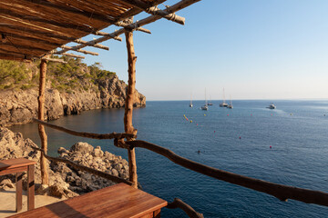 Restaurante al borde del mar en Cala Deià (Mallorca). Vista al mar desde las mesas de madera.