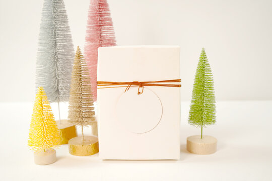 Christmas holiday gift tag, party favor mockup styled with minimalist pastel Scandi Christmas trees against a white background.