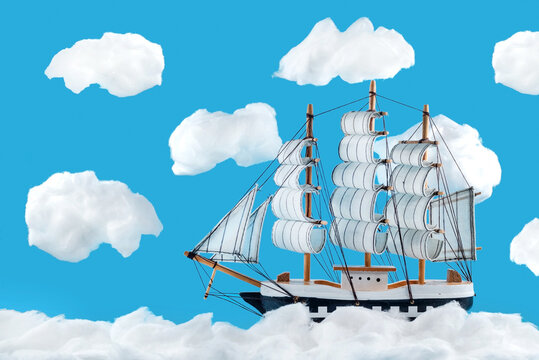 Wooden boat on the waves of cotton wool. Cotton clouds