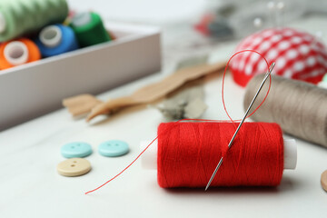 Threads and other sewing supplies on white marble table