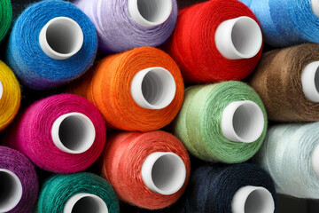 Top view of colorful sewing threads as background, closeup