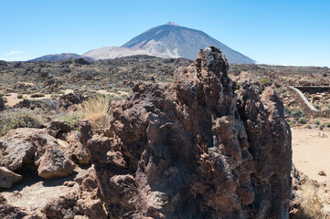 The Teide volcano on the island of Tenerife with volcanic rocks in the foreground