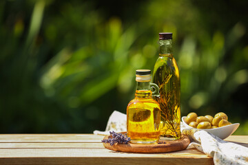 Different cooking oils and ingredients on wooden table against blurred green background, space for text