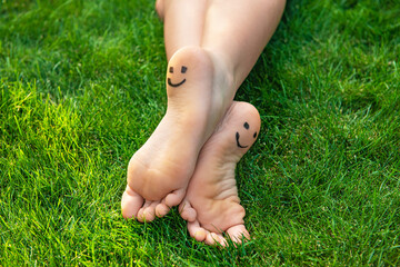 Teenage girl with smiling faces drawn on heels outdoors, closeup