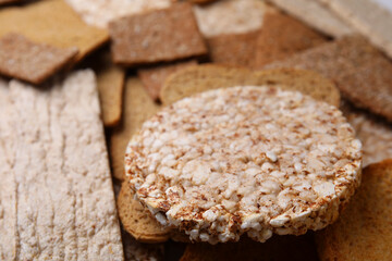 Fresh rye crispbreads, crunchy rice cakes and rusks as background, closeup
