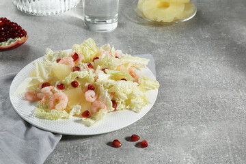 Delicious salad with Chinese cabbage, shrimps and pineapple served on grey table, space for text