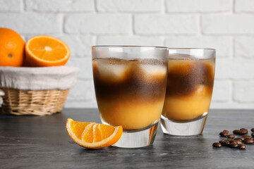 Tasty refreshing drink with coffee and orange juice on grey marble table
