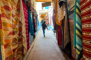 Fototapeta na wymiar Traditional Moroccan carpets hanging on the street marketplace in the medina of Fez