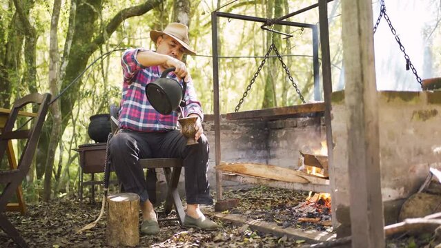 Ethnic man serving mate against barbecue rack in garden