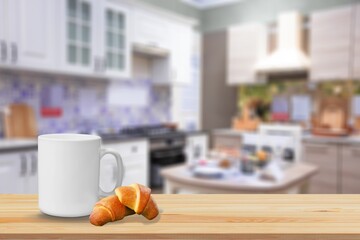Tasty fresh croissant and cup of coffee on table