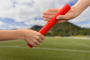 Sport person hands passing a baton during run