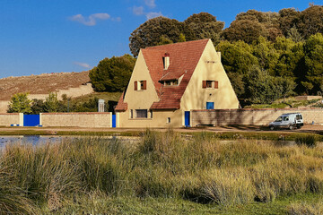 An old stone house with red tile roof in a rural area