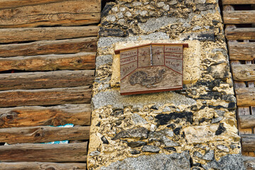 Antique weather indicator in Irone, medieval Alpine village in Trentino, Italy, a touristic destination seen on a sunny autumn day