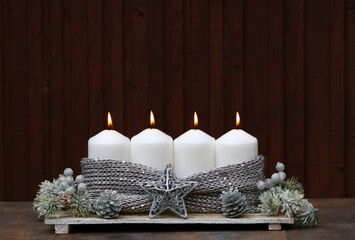 Fotoserie zur Adventszeit: Dekoration zum vierten Advent vier brennende Kerzen mit  Dekoration vor...