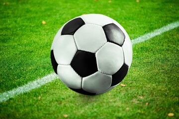 Fototapeta na wymiar Classic Football Ball on green grass at Stadium