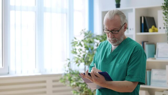 Senior man doctor working in his office in rehabilitation center, physiatrist